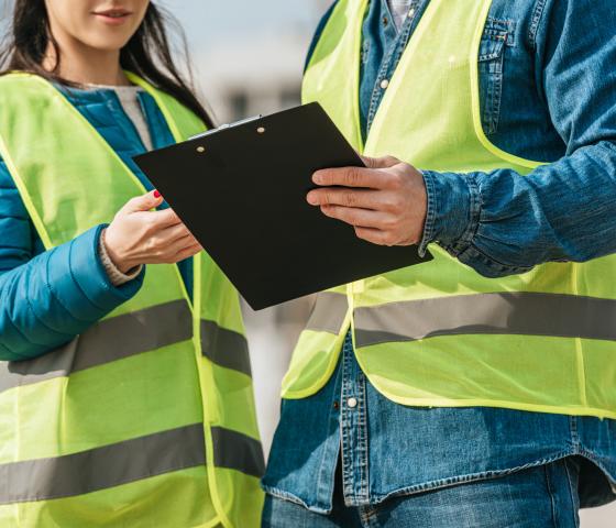 Woman and Man wearing PPE, holding clipboard