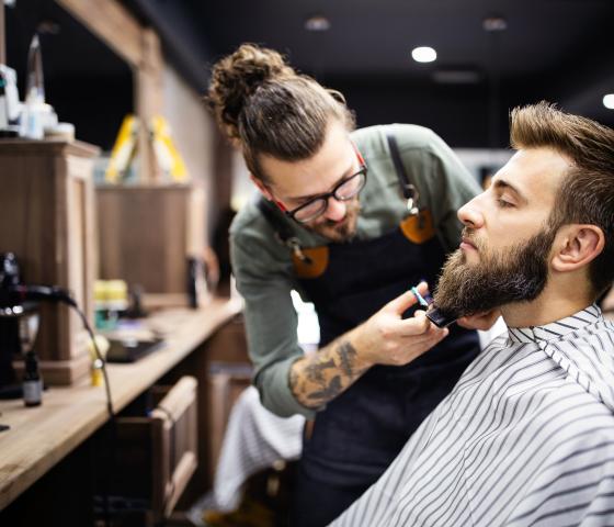person getting a beard trim by a barber